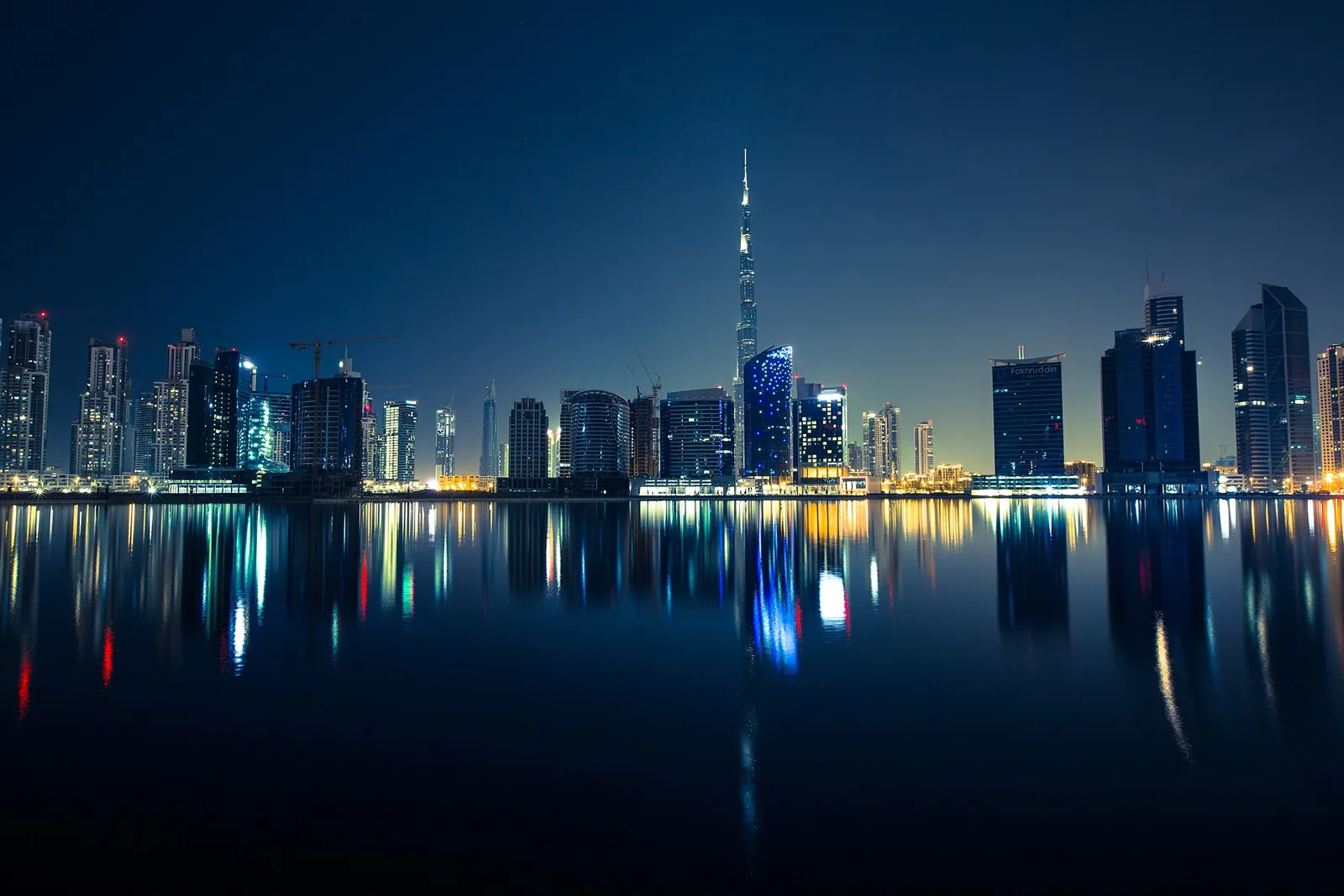 Skyline von Dubai mit Burj Khalifa bei Nacht, im Wasser gespiegelt